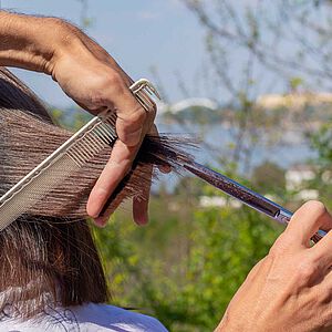 Friseur schneidet Haare im Freien